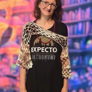 A person wearing a handmade crochet Bell Sleeve Fairy Shrug draped over a black 