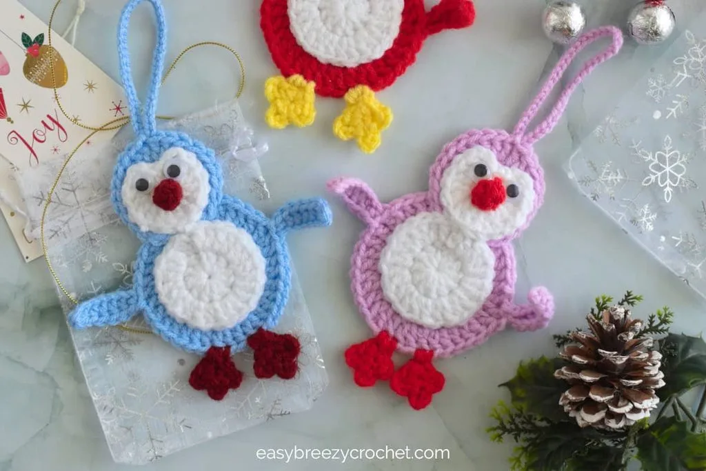 Small amigurumi penguin wearing a red holiday scarf