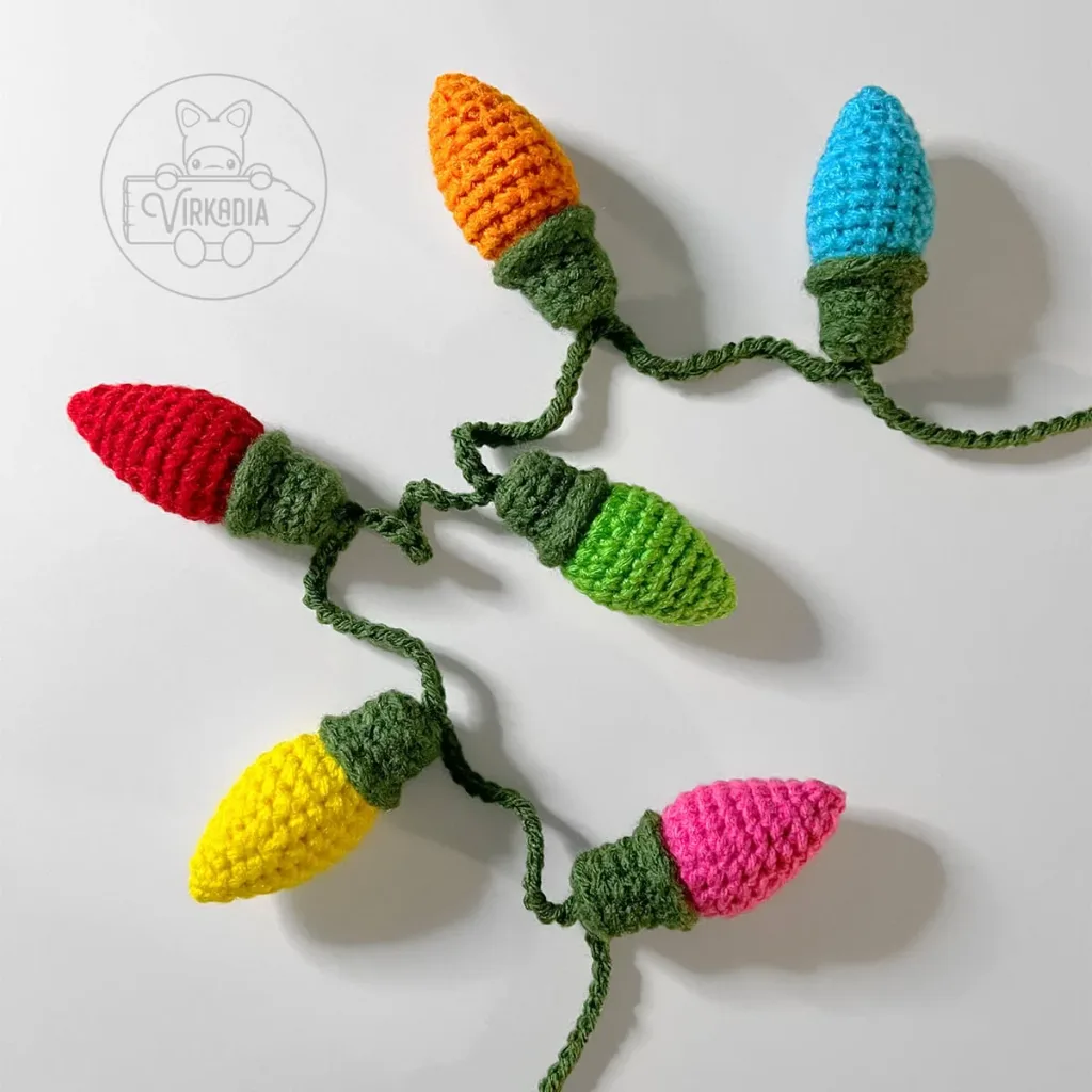Crocheted Christmas bulb garland draped over a white shelf